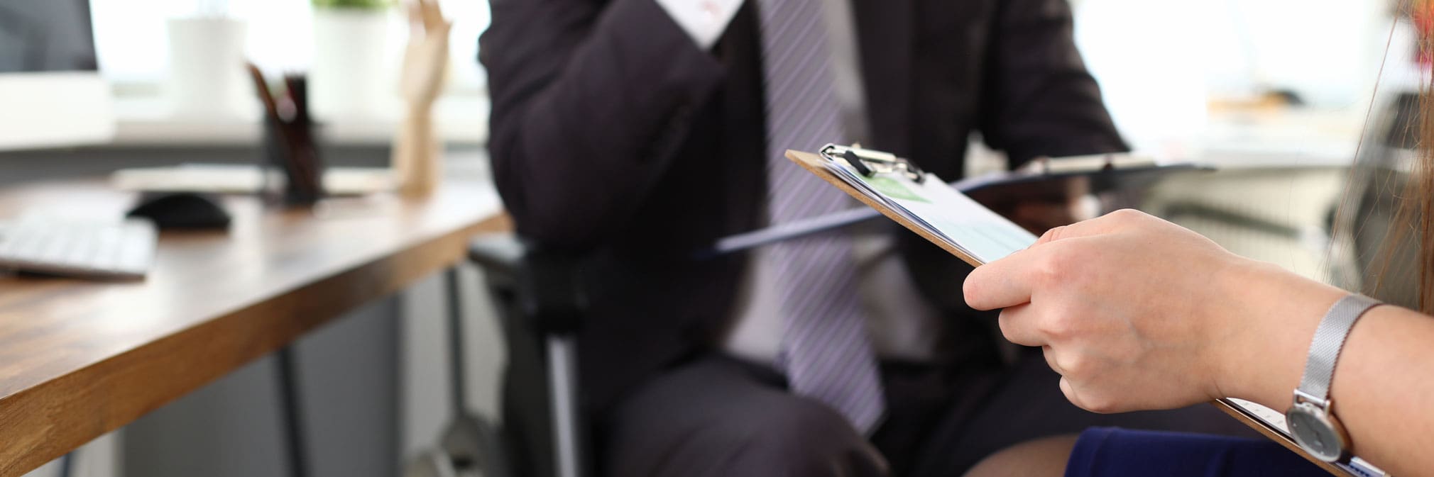 Male boss on wheelchair speaks with woman in office. Prestigious job for people with disabilities